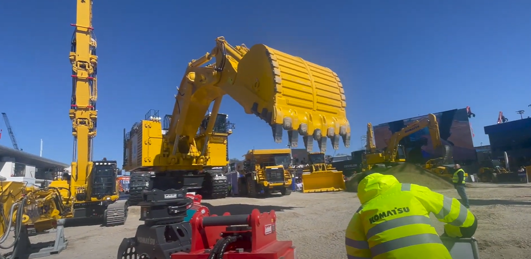 alt="Excavadora eléctrica gigante Komatsu PC-7000-E durante su presentación en BAUMA 2025, con doble motor eléctrico"