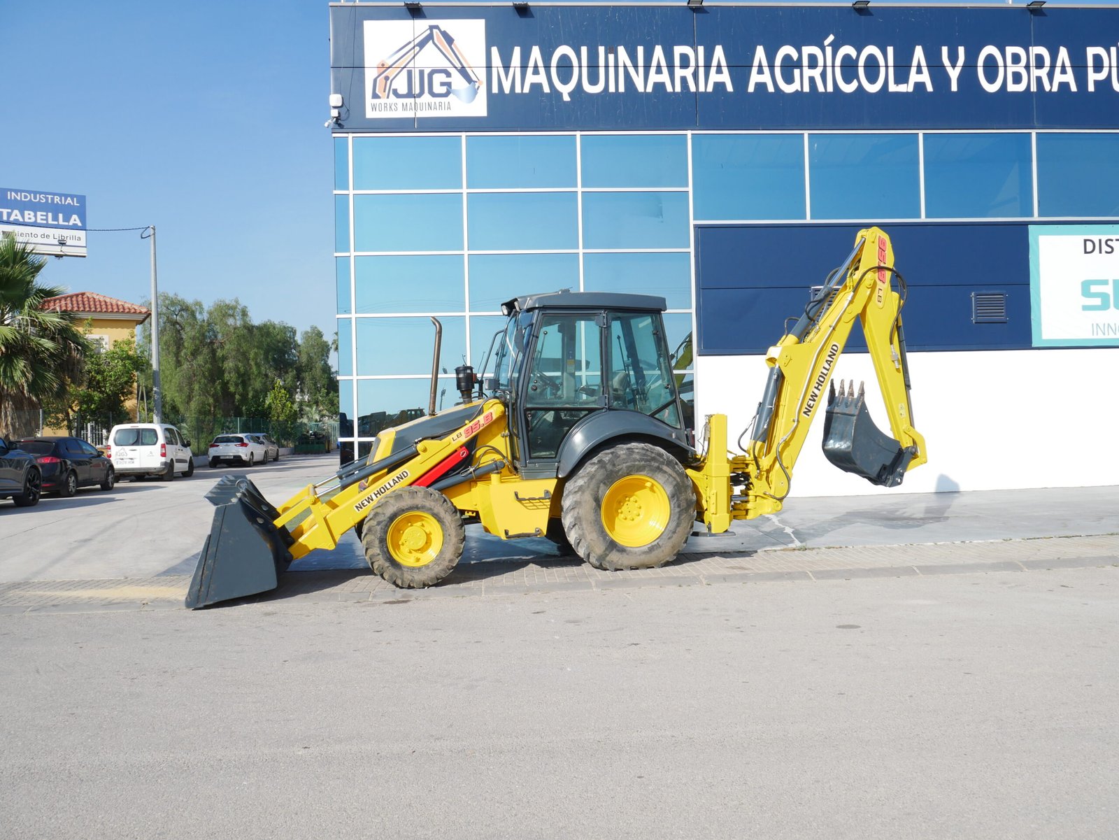 alt="Retroexcavadora New Holland LB95 de 2006 con aire acondicionado, instalación de martillo y mandos pilotados"
