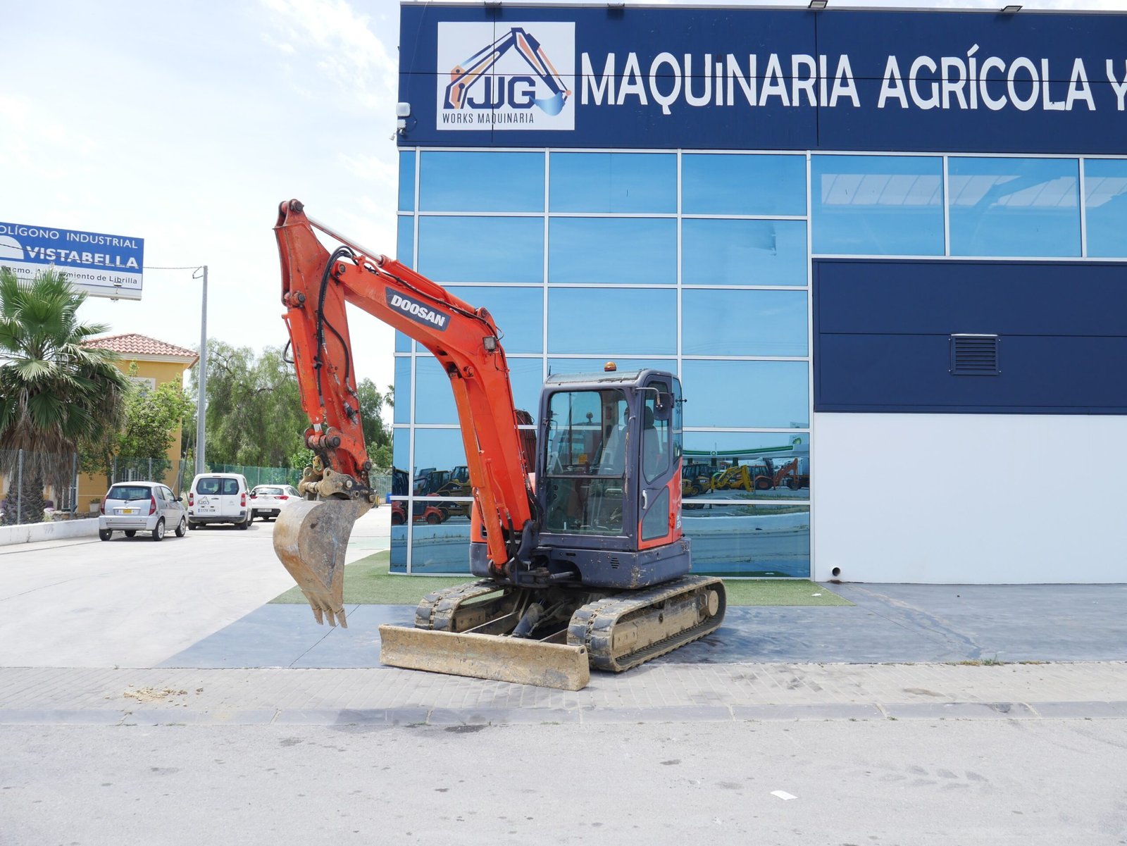 Miniexcavadora Doosan DX 60 R equipada con enganche rápido y tres cazos en entorno de obra