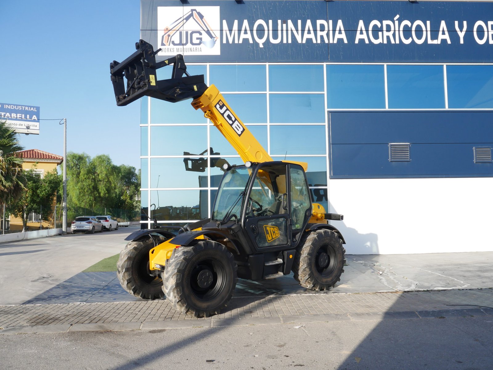 Manipulador telescópico JCB 531-70 con pinzas porta palets y enganche rápido en entorno de obra