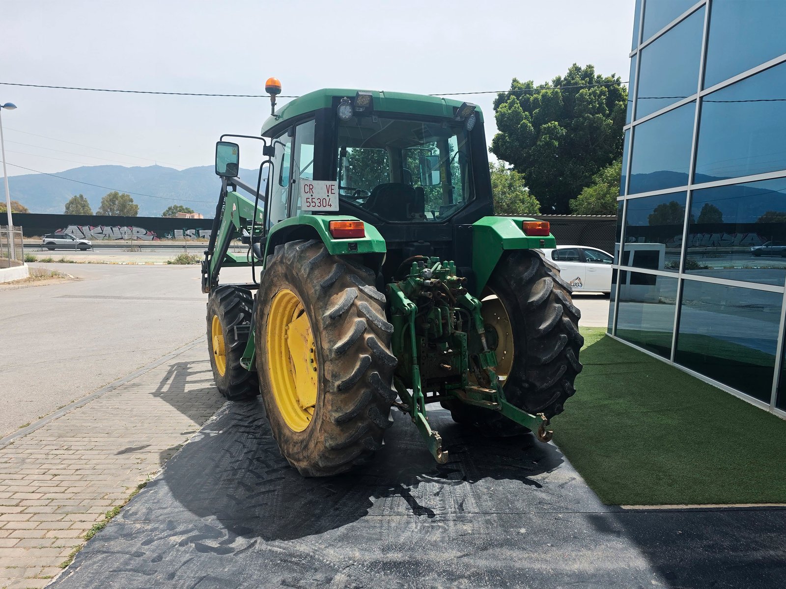 Pala cargadora John Deere 6310 en uso Tractor John Deere 6310 listo para trabajar John Deere 6310 en transporte agrícola Panel de control John Deere 6310
