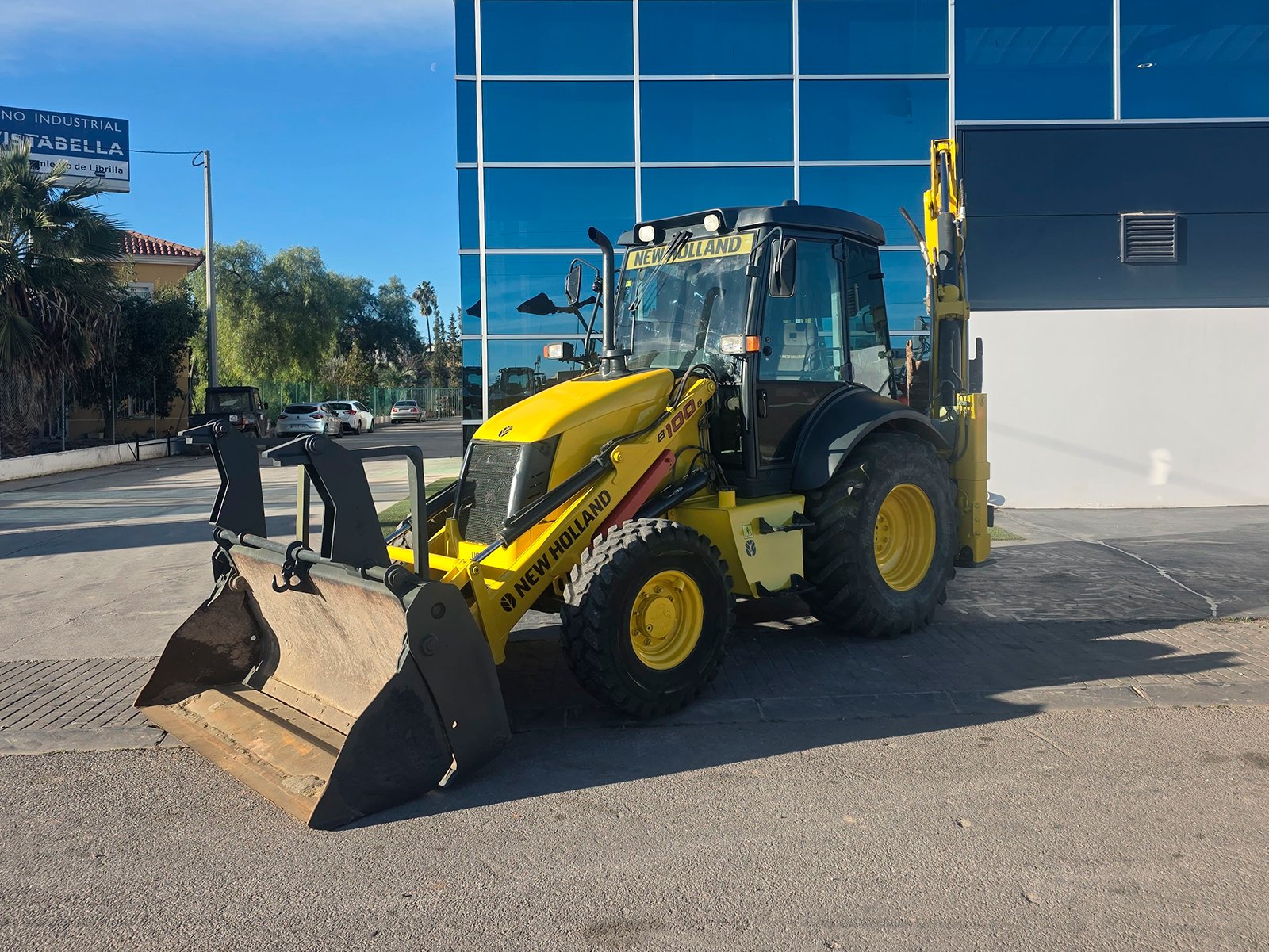 New Holland B100B segunda mano 2008 vista lateral Retroexcavadora New Holland B100B 92 CV en obra New Holland B100B con almeja y cazos Vista frontal New Holland B100B usada