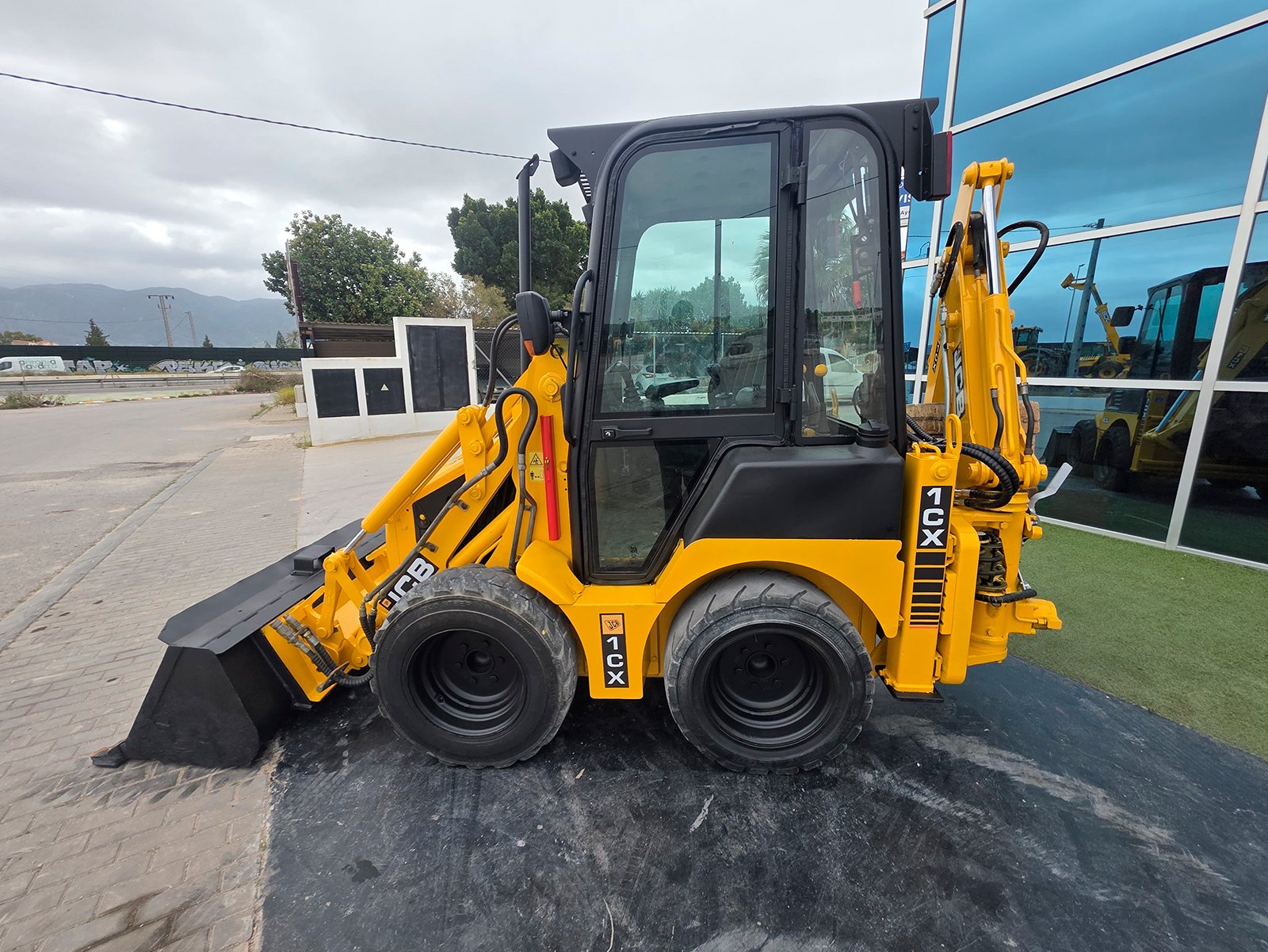 Vista diagonal JCB 1CX JCB 1CX excavando zanja Cazo frontal JCB 1CX 0,3 m3 Sistema hidráulico JCB 1CX