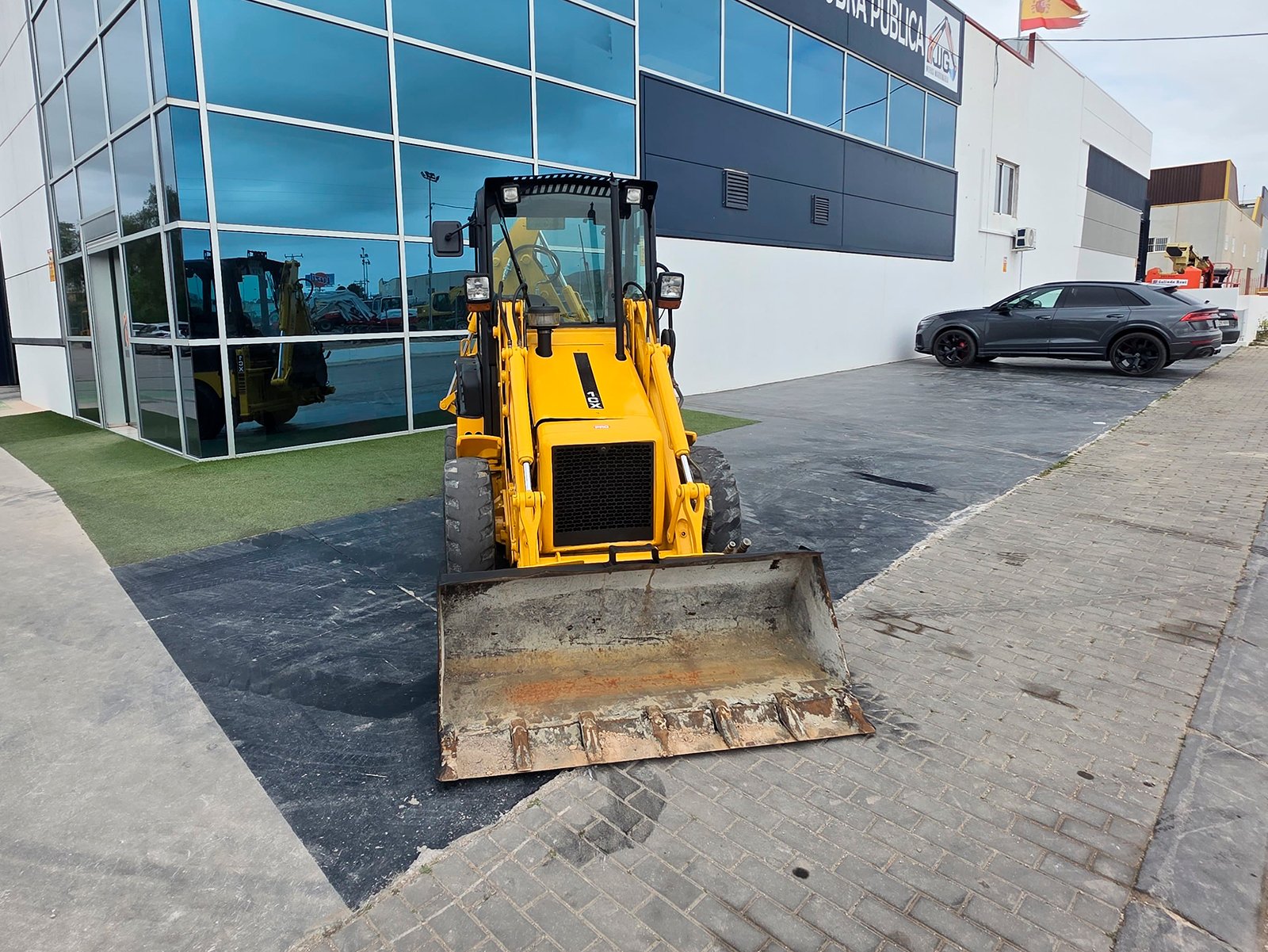 JCB 1CX trabajando en espacio reducido Instalación hidráulica martillo JCB 1CX Mini retro JCB 1CX compacta JCB 1CX maquinaria construcción pequeña