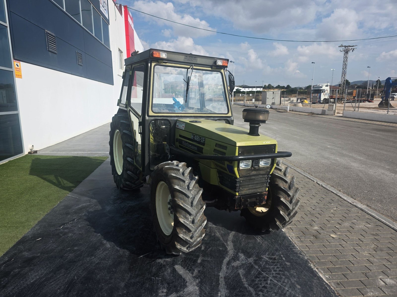 Hürlimann H-481-XF trabajando en finca Cabina tractor Hürlimann H-481-XF Vista diagonal Hürlimann H-481-XF Tractor agrícola de segunda mano Hürlimann