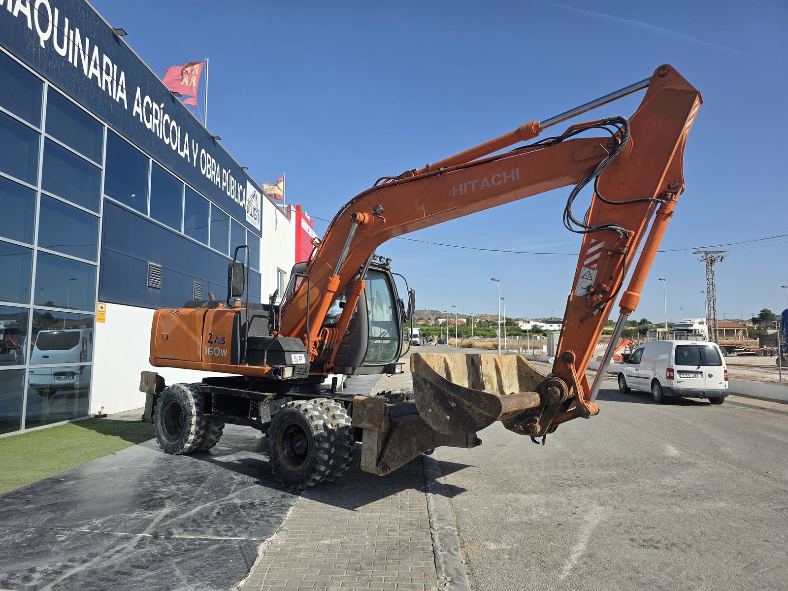 Vista frontal Hitachi ZX160W usada Motor Isuzu Hitachi ZX160W 122 CV Excavadora de ruedas Hitachi trabajando Hitachi ZX160W con enganche rápido Excavadora Hitachi con 2 cazos incluidos Vista diagonal Hitachi ZX160W