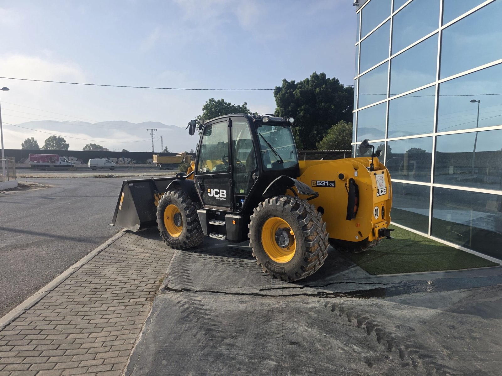 Vista diagonal JCB 531-70 Manipulador telescópico 3.100 kg JCB 531-70 elevando palets Brazo telescópico JCB 531-70
